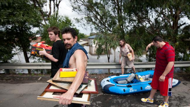 Residents of Rocklea used an inflatable boat to retrieve family photos and other prized possessions in Brisbane on Wednesday, January 12, 2011.