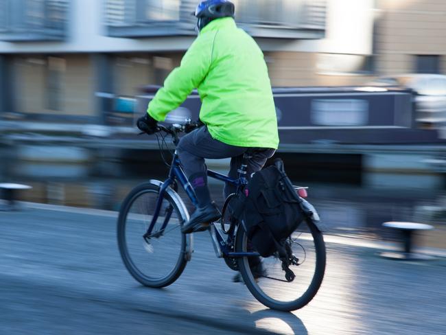 A person cycling down a canal walkway