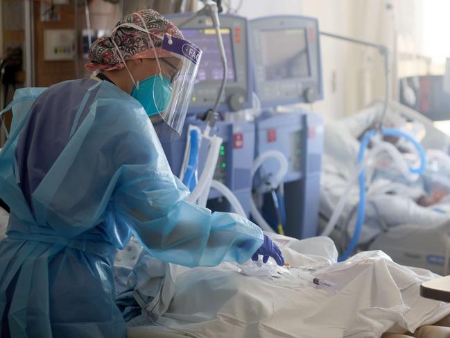 TORRANCE, CALIFORNIA - JANUARY 21: (EDITORIAL USE ONLY) U.S. Air Force 1st Lt. Allyson Black, a registered nurse, cares for COVID-19 patients in a makeshift ICU (Intensive Care Unit) at Harbor-UCLA Medical Center on January 21, 2021 in Torrance, California. The hospital is utilizing about 20 military medical personnel deployed by the Department of Defense to help shore up overwhelmed staff at a number of medical centers in Southern California. The hospital is over its ICU capacity due to the coronavirus and has been forced to treat multiple COVID-19 patients who require ICU level care together in rooms which were designed for lower levels of care. California has become the first state in the nation to record 3 million known COVID-19 infections. Los Angeles County reported more than 250 COVID-19 fatalities on January 21.   Mario Tama/Getty Images/AFP == FOR NEWSPAPERS, INTERNET, TELCOS & TELEVISION USE ONLY ==