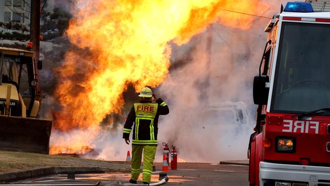 A Firefighter stands in front of huge gas fireball on the corner of Narrabeen and Ocean streets at Narrabeen in December 2004. Picture: News Corp