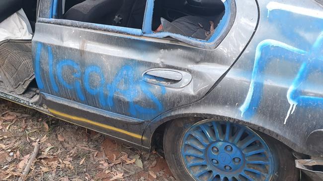 An abandoned car, covered in hate speech and swastikas, has been left by the side of a Yellingbo road for a week.