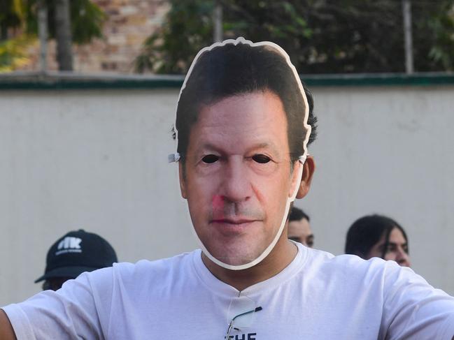 Imran Khan's Pakistan Tehreek-e-Insaf (PTI) party supporter wears Khan's mask whilst he protests against the alleged skewing in Pakistan's national election results, in Karachi on February 11, 2024. Pakistan police warned on February 11 they would come down hard on illegal gatherings after the party of jailed former prime minister Imran Khan urged supporters to protest against alleged rigging in last week's election. (Photo by Asif HASSAN / AFP)