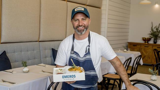 John Omeros inside Omeras Fishbar at Benowa Gardens Shopping Centre showing off a takeaway container he designed to include spaces for sauce containers. Picture: Jerad Williams