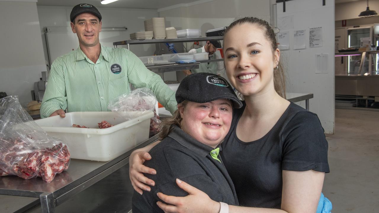 Gabe Hoopert (left) enjoys her job at The Paddock helped by her support worker Jemma Melia. The Paddock owner Ted Ellison in background. Tuesday, October 26, 2021. Picture: Nev Madsen.