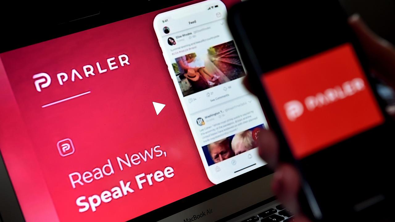 Social media app from Parler displayed on a smartphone with its website in the background. Picture: Olivier Douliery/AFP