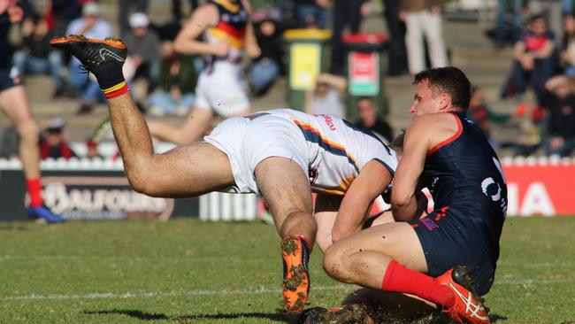 Adelaide’s Matthew Wright runs into a Peter Bampton tackle. Picture: Russell Millard/AAP