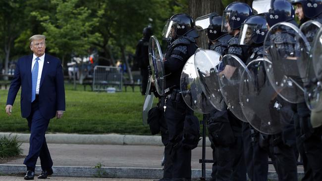 President Donald Trump walks past police in Lafayette Park after he visited outside St. John's Church across from the White House.