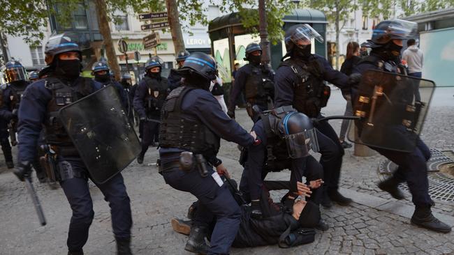 Police arrest a man during a protest on April 24 in Paris.