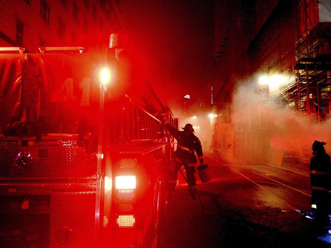 A firefighter prepares to extinguish a dumpster fire on Taylor St. in San Francisco.