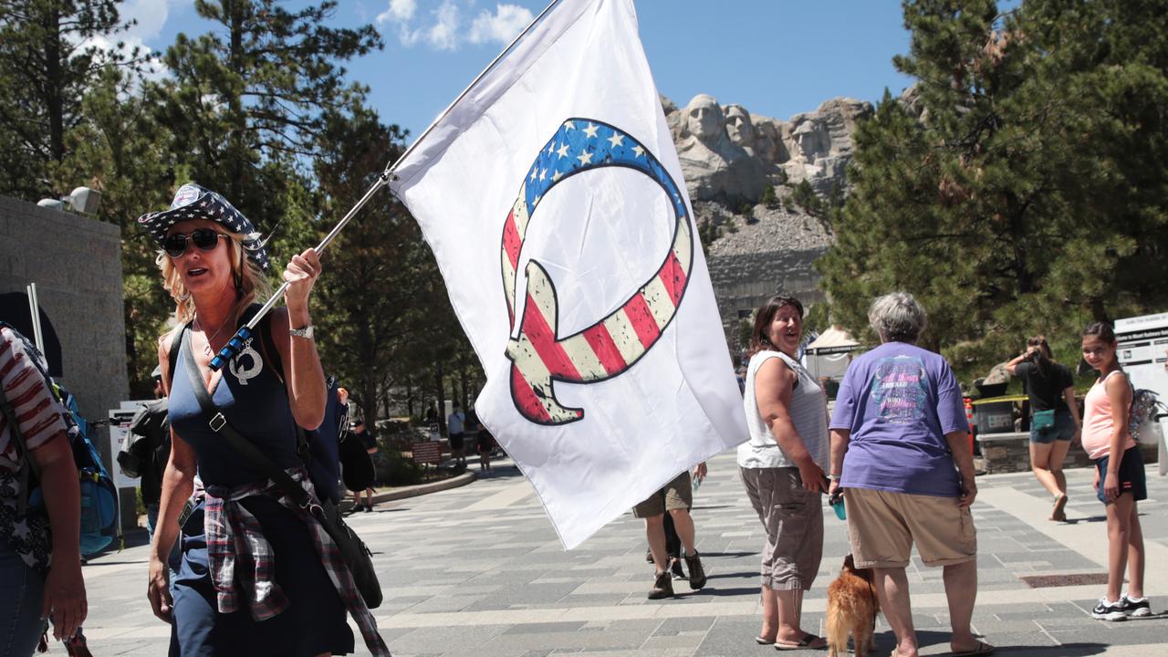 Donald Trump supporter holding a QAnon flag at Mount Rushmore last July. Picture: Scott Olson/ Getty Images
