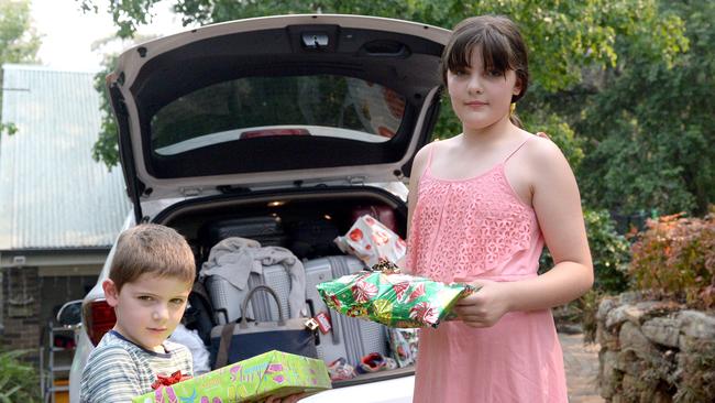 Samuel, 5, and his sister Jayde, 11, prepare to leave the area as bushfire threatens their home. Picture: Jeremy Piper