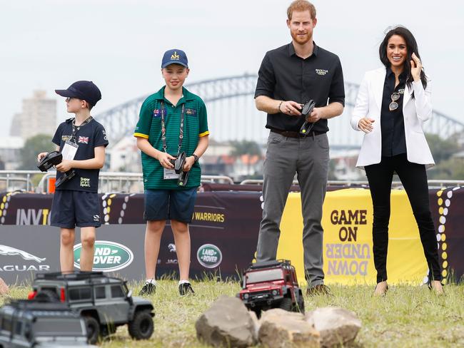 Meghan watches on as Prince Harry takes on Danyan Jones in a remote control challenge on Cockatoo Island. Picture: Chris Jackson