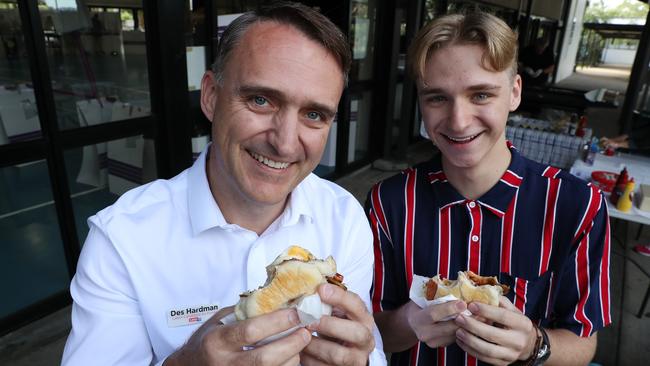 Forde Labor candidate for Forde Des Hardman eating a bacon and egg roll with son Julian, 18, after casting their vote, Shailer Park State High School. Picture: Liam Kidston.