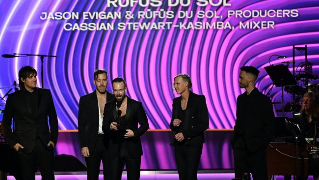 Jason Evigan, band members Rufus Du Sol and Cassian Stewart-Kaimba accept the trophy for best dance/electronic recording for Alive at the Grammy Awards. Picture: Valerie Macon/AFP