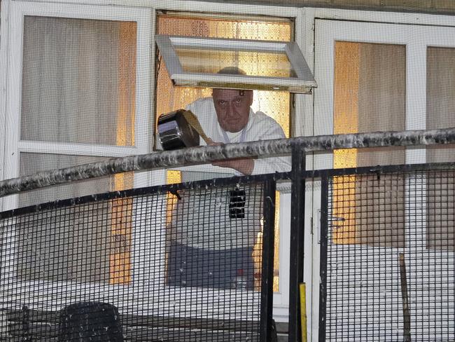 A man knocks a pot from his window near West Middlesex University Hospital to show his support for NHS staff. But helping the elderly at home may spread the virus. Picture: AP Photo