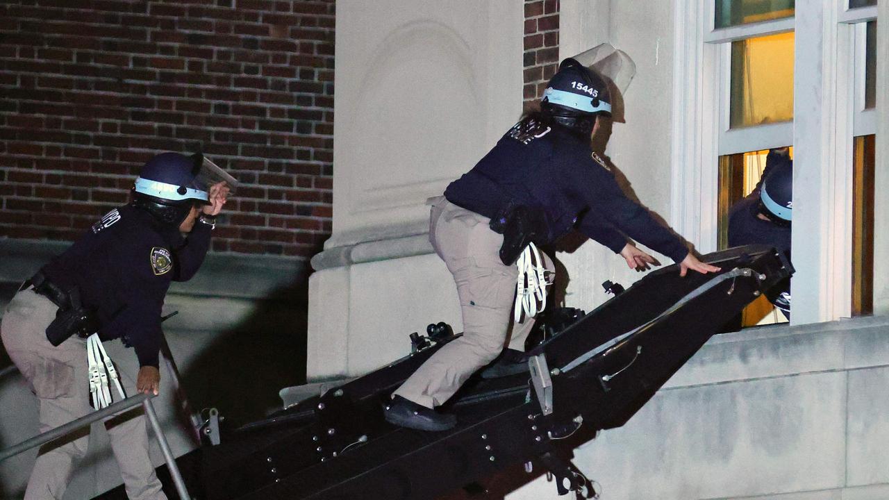 NYPD officers in riot gear break into a building at Columbia University. Picture: KENA BETANCUR / AFP)