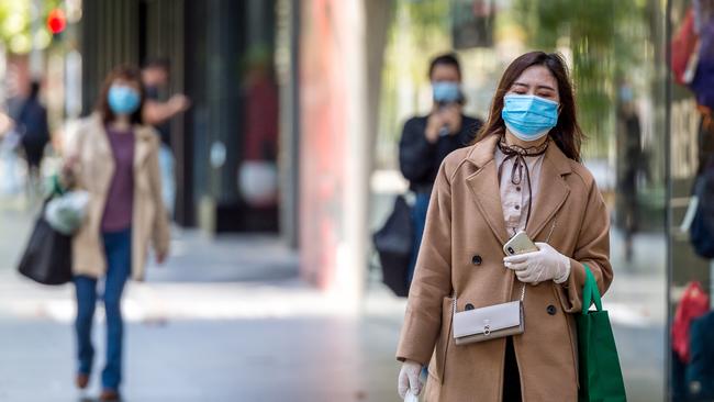 People wear masks walking through Melbourne’s CBD. Picture: Jake Nowakowski