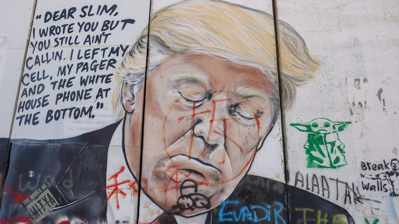 A defaced mural painting of US President Donald Trump on Israel's controversial separation barrier on January 14, 2021. Picture: AHMAD GHARABLI / AFP,