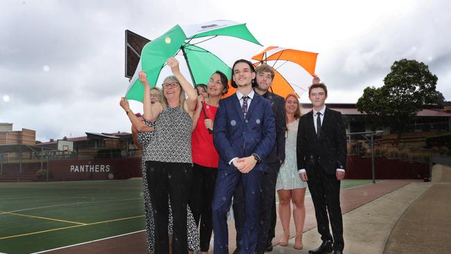 Pacific Pines High formal, at the school. Staff and students take cover from the weather. Picture Glenn Hampson