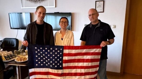 Wall Street Journal Reporter Evan Gershkovich, Radio Free Europe journalist Alsu Kurmasheva, and former US Marine Paul Whelan pose with an American flag in the airport lounge in Ankara, Turkey. Gershkovich, Kurmasheva, Whelan and others were involved in a multinational prisoner swap with Russia. Picture: US Government/Getty Images