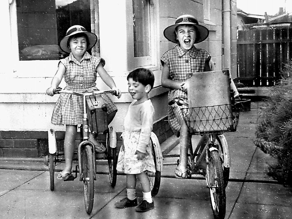 <p>Arnna and Jane ready for school on their bikes, while Grant looks on.</p>