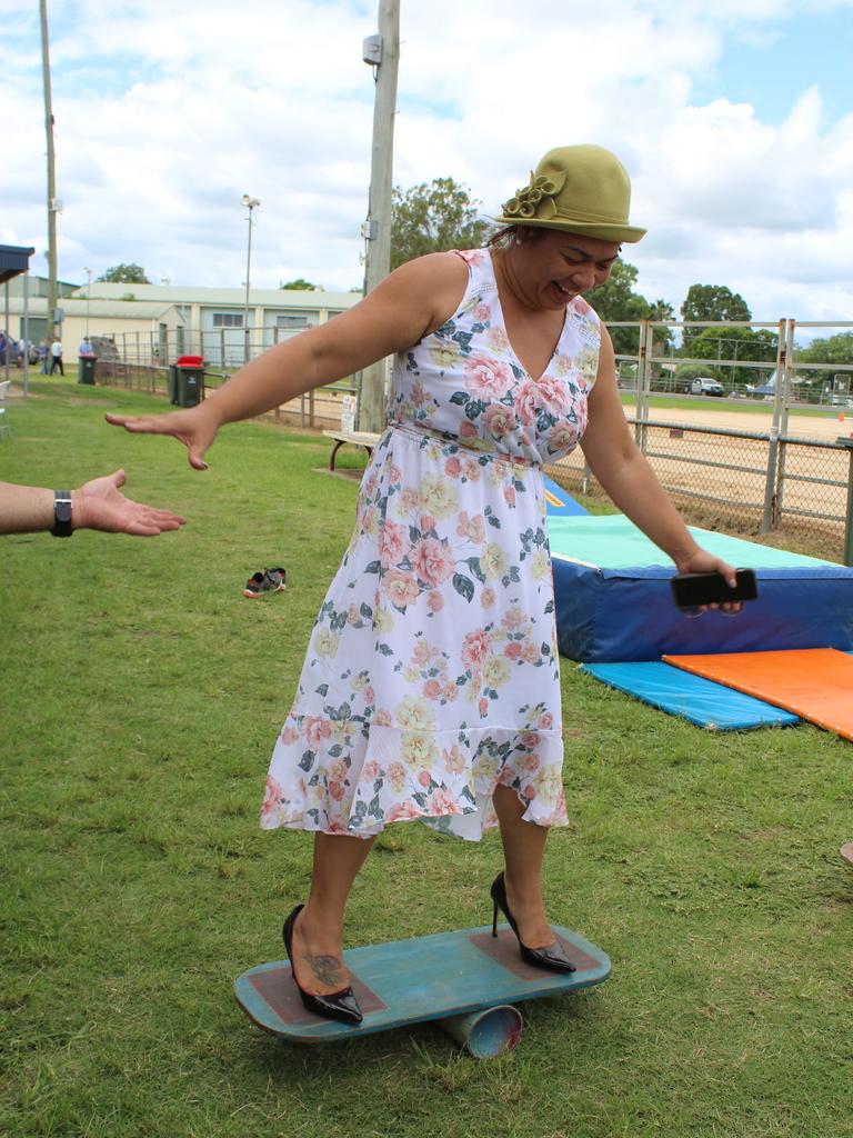 Abigail Andersson trying her best to master the wobble board in high heels at the Murgon Show. Photo: Laura Blackmore