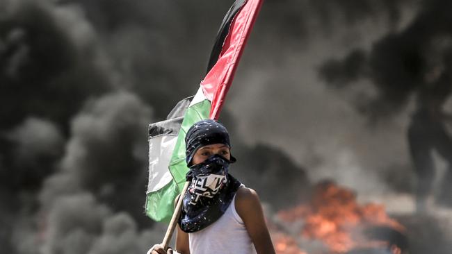 A Palestinian boy holding his national flag. Picture: AFP