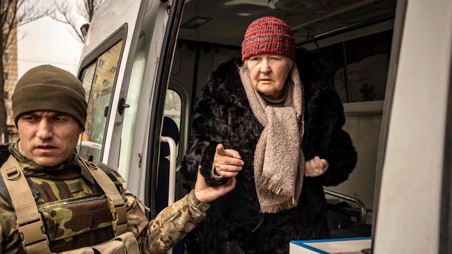 Poet Tamara Osypchuk, 72, is helped out of an ambulance after fleeing her home in Irpin, in the suburbs of Kyiv. Picture: AFP