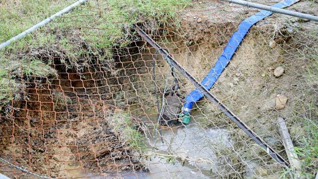 Water is being pumped out of the large trenches outside the residents' houses. Picture: Steph Allen