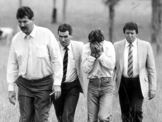 Detective Sergeant Ian Kennedy (left) and fellow police officers escort Michael Murphy (head in hands) one of the men convicted of murder of Sydney nurse Anita Cobby to scene of the crime on February 27, 1986. Picture: Andrew Stark.