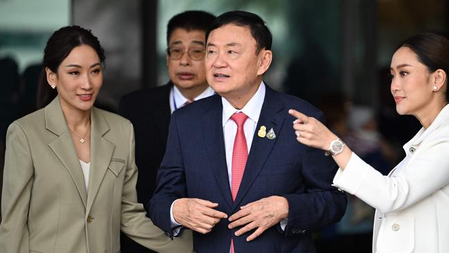 Former Thai prime minister Thaksin Shinawatra with daughters Paetongtarn Shinawatra, right, and Pintongtha Kunakornwong, left, after landing at Bangkok’s Don Mueang airport on Tuesday. Picture: AFP