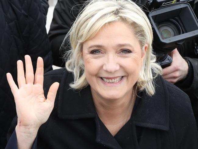 TOPSHOT - French presidential election candidate for the far-right Front National (FN) party Marine Le Pen waves as she walks on the beach during her visit in Nice, southeastern France, on February 13, 2017. / AFP PHOTO / VALERY HACHE