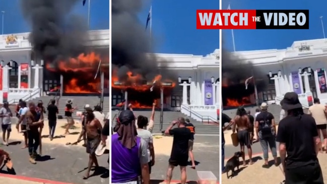 Demonstrators chant and dance as fire burns on door of Old Parliament House