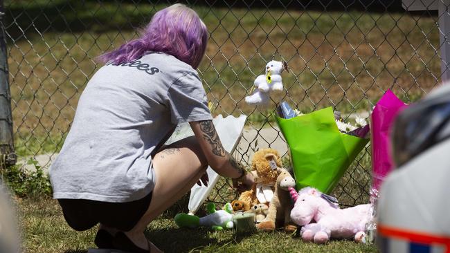 A woman adds to a growing tribute to two little girls who died at Waterford West yesterday. Picture: Attila Csaszar/AAP