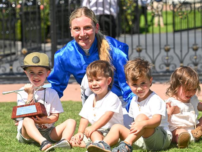 MELBOURNE, AUSTRALIA - MARCH 09: Jamie Kah poses with the late Dean Holland's children after receiving the Dean Holland trophy after riding Cylinder to win Race 5, the Yulong Newmarket Handicap, during Melbourne Racing at Flemington Racecourse on March 09, 2024 in Melbourne, Australia. (Photo by Vince Caligiuri/Getty Images)