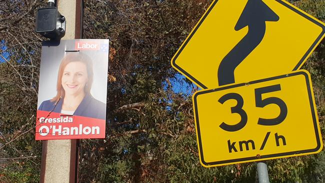 An election corflute from the most recent federal election, next to a road sign. Picture: Colin James