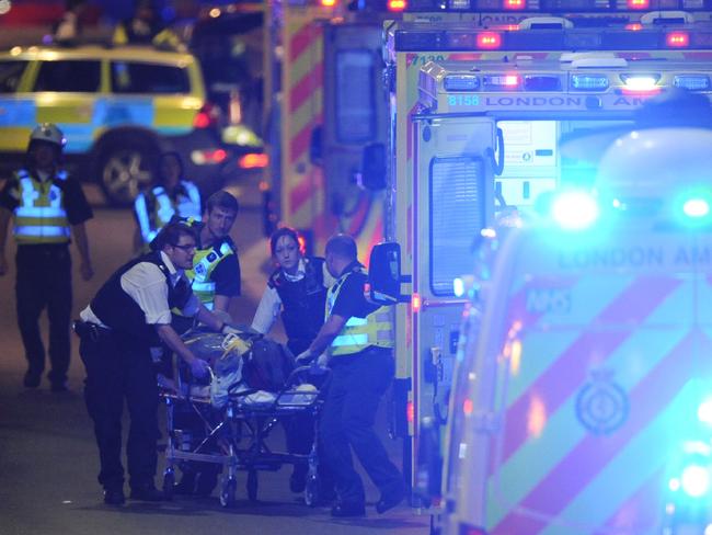 Police officers and members of the emergency services attend to a person injured in an apparent terror attack on London Bridge. Picture: AFP / DANIEL SORABJI