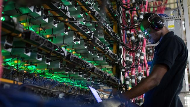 A technician monitors cryptocurrency mining rigs at a facility in Quebec, Canada. Pic: Bloomberg