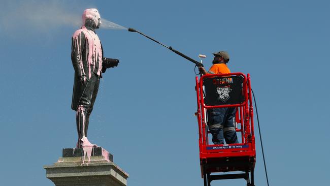 A worker cleans the Captain Cook statue after it was covered in pink paint in 2018.