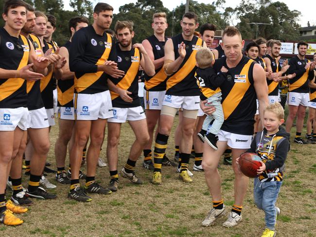 Blair Harvey runs out for his 300th game with sons Brax and Hunter.