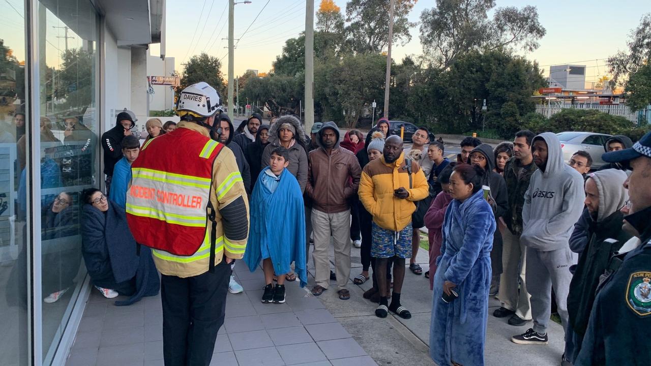 Residents gather outside the unit block.