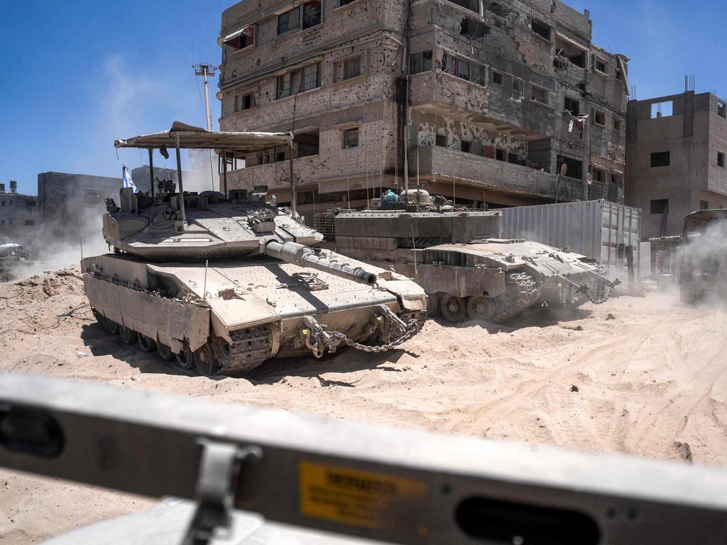 Israeli tanks next to destroyed buildings during a ground operation in the southern Gaza Strip. Picture: Ohad Zwigenberg/AFP