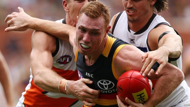 Tom Lynch of the Crows is tackled by Phil Davis of the Giants.