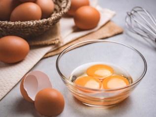 Close up image of three eggs yolk in clear bowl are one of the food ingredients on the restaurant table in the kitchen to prepare for cooking. Organic chicken eggs food ingredients concept