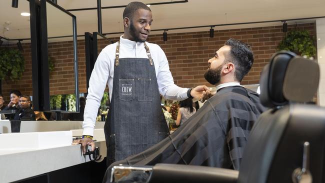 Granville TAFE student Khalid Nassor flexes his skills on Esho Dawood at the upgraded facilities. Picture: Matthew Vasilescu