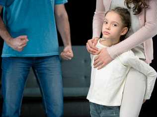 portrait of daughter hugging mother with aggressive father behind on black, family violence concept