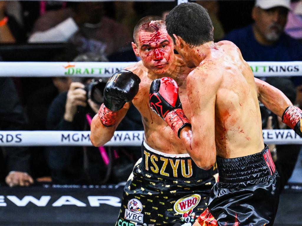 Tim Tsiu (gold and black shorts) and Sebastian Fandora (red and black shorts) exchange punches during the super welterweight title bout.