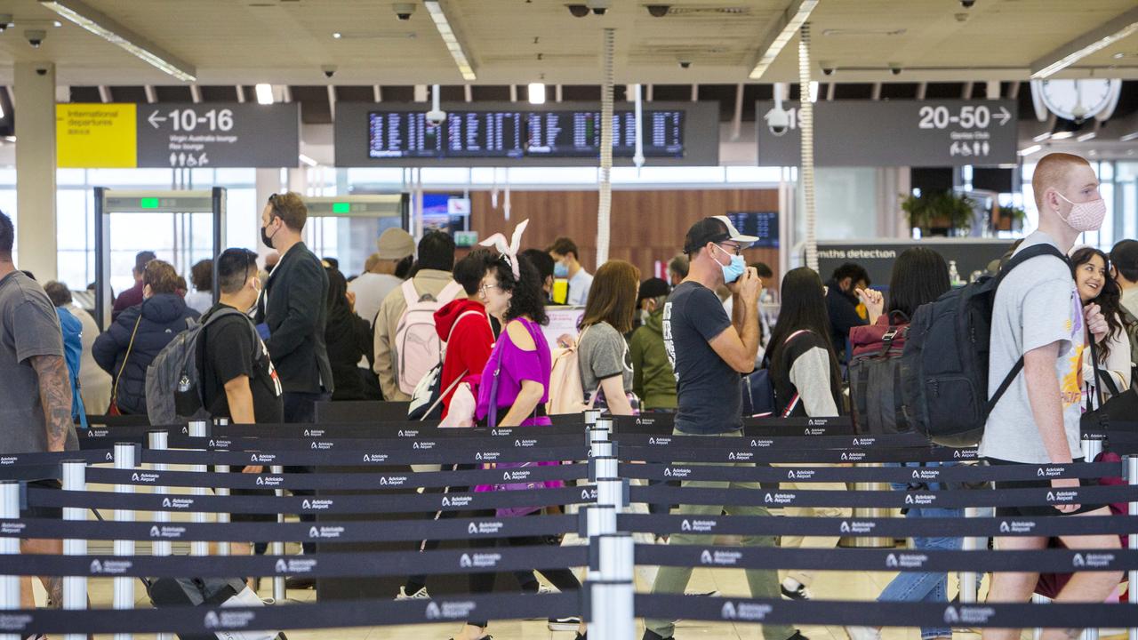 Passengers queue at Adelaide Airport ahead of holiday break. Picture Emma Brasier.