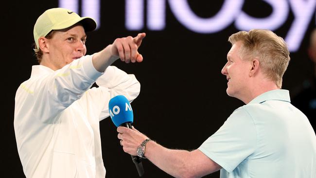 Sinner can’t hide a smile as he talks to Jim Courier. (Photo by DAVID GRAY / AFP)