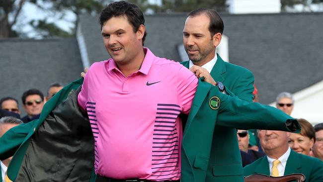 Patrick Reed of the United States is presented with the green jacket by Sergio Garcia of Spain after winning the 2018 Masters Tournament. Picture: Getty Images.